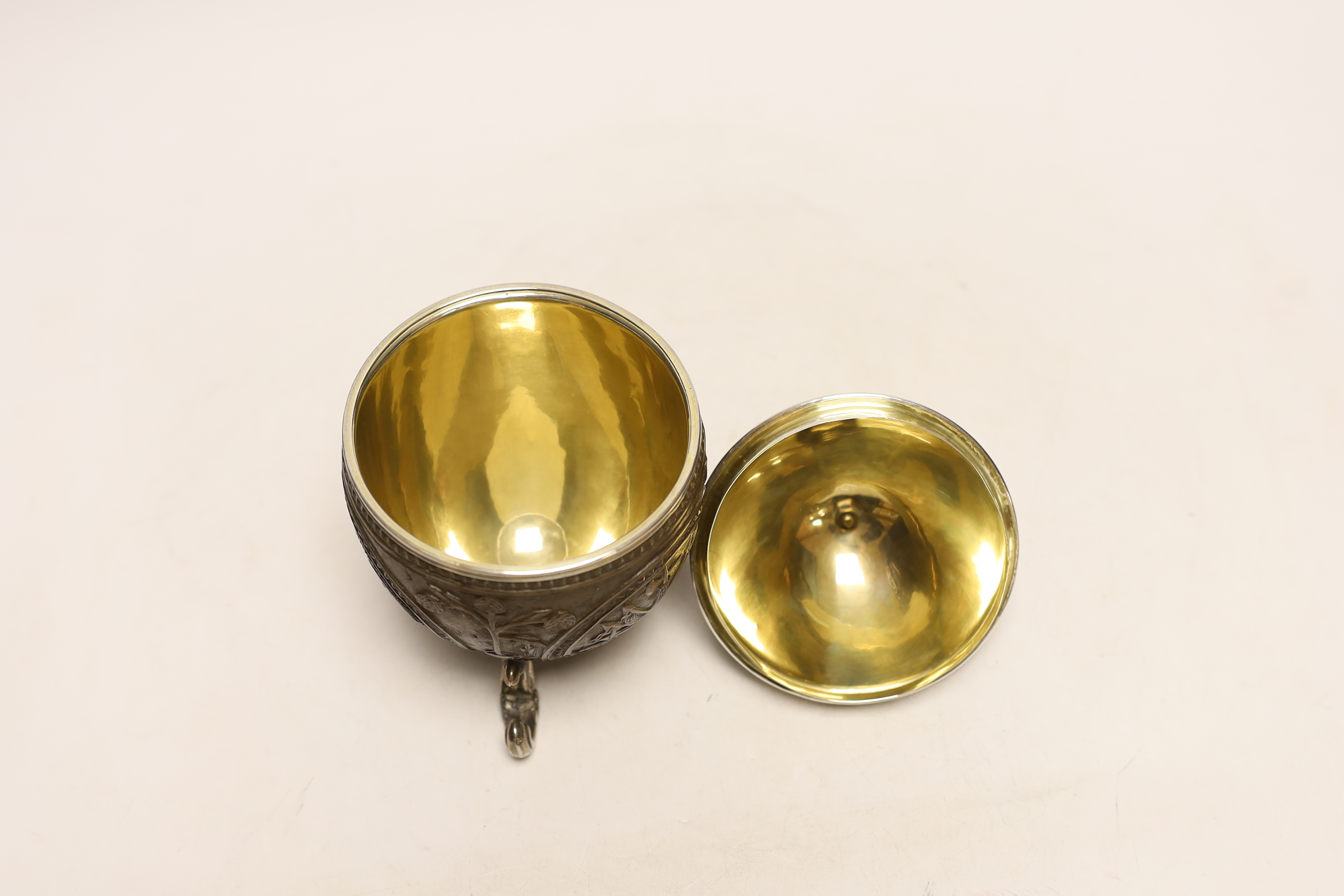 A unmarked white metal mounted coconut cup, on three scroll feet, height 17.4cm.